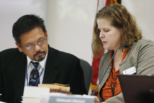 Dr. Ray Estacio, a member of the Colorado Board of Health, confers with Deborah Nelson, board administrator, during testimony to add post-traumatic disorder to the list of ailments eligible for treatment with medical marijuana during a hearing before the board in Denver. (David Zalubowski, AP)