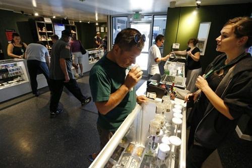 Customers shop at the Grass Station dispensary in Denver. Because of federal banking regulations, Colorado's $700-million-a-year industry runs almost entirely on cash. Image: Brennan Linsley, Associated Press via Los Angeles Times 