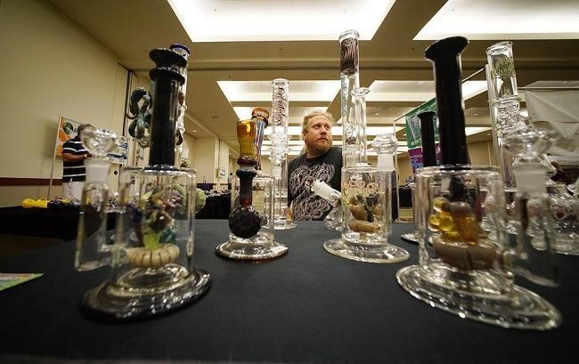 Glass artist Mark Nowicki displays his handmade bongs at the O.G Tubes booth at the marijuana expo at the Hawaii Convention Center on July 19. Image: Cory Lum, Civil Beat. 