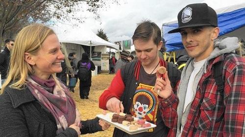 Becca Marston, a sales rep for Utopia Farms, hands out free samples of cannabis-infused macaroons to Blake Almira, 21, right, and a friend. Image: Robin Abcarian, Los Angeles Times