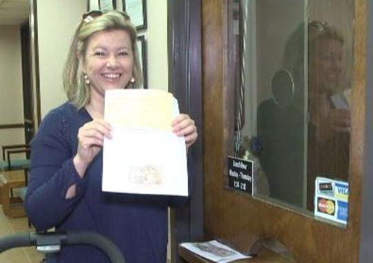 Erin Cleveland holding up Lainey's medical marijuana registration card?(Photo: Hopper, Christopher)