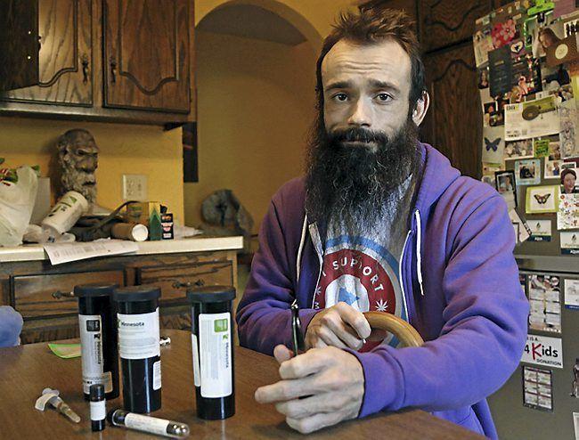 Jonathan Holmgren with medical cannabis products at his home in Spring Lake Park, Minn. Holmgren is back to using the raw plant that the state still deems illegal to treat his Crohn's disease. AP Photo/Jim Mone via TwinCities.com
