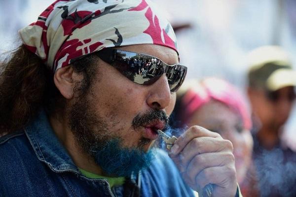 A man smokes marijuana during a rally in front of the Supreme Court of Justice in Mexico City on November 4, 2015. AFP Photo: Alfredo Estrella 
